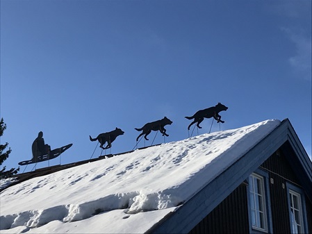 Skulturen von Schlittenhunden auf einem Hausdach