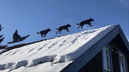 Skulturen von Schlittenhunden auf einem Hausdach