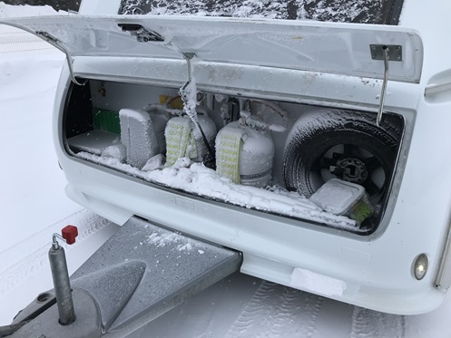 Flaschenkasten am Wohnwagen voll mit Schnee